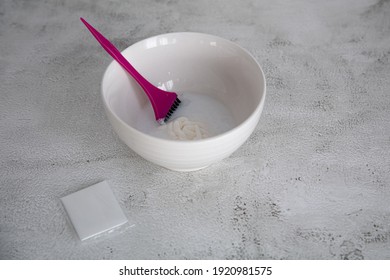 On The Table Is A Bowl With Hair Dye And A Brush. Home Coloring Concept.