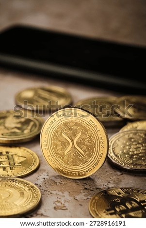 On a table are coins representing various cryptocurrencies. Highlighting the Xrp cryptocurrency.