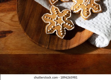 On the table is a delicious traditional ginger cookie with icing sugar in the shape of snowflakes.
