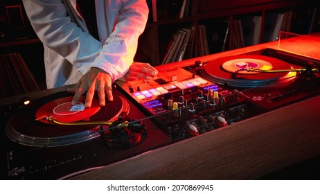 On The Table, The DJ Is Playing A Record Using Two Vinyl Turn Table Players Playing Songs In Succession.