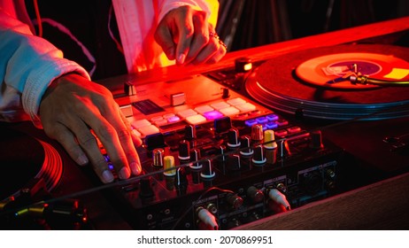 On The Table, The DJ Is Playing A Record Using Two Vinyl Turn Table Players Playing Songs In Succession.