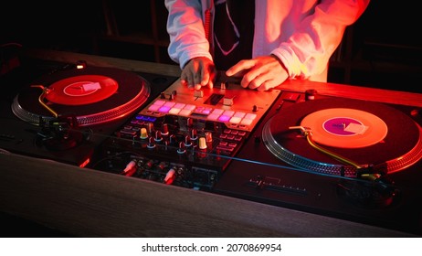 On The Table, The DJ Is Playing A Record Using Two Vinyl Turn Table Players Playing Songs In Succession.