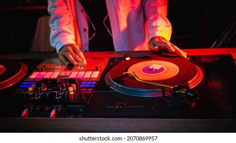 On The Table, The DJ Is Playing A Record Using Two Vinyl Turn Table Players Playing Songs In Succession.