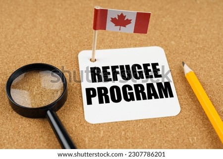 On the table is the flag of Canada, a pencil, a magnifying glass and a sheet of paper with the inscription - Refugee Program