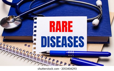 On the table are notepads, a stethoscope, a pen and a sheet of paper with the text RARE DISEASES. Medical concept - Shutterstock ID 2053404293