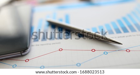 On table is report with graph and silver pen. Preliminary analysis target audience. Feature calculating interest on loan or deposit. Increasing sales, opening branches, creating franchise