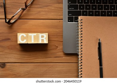 On the table there is a word cube lined CTR with laptop computers and glasses. It is an abbreviation for the word Click Through Rate.