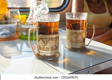 On The Table In The Train Compartment Are Glasses With Tea In Metal Cup Holders.