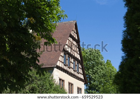 on a very sunny day in june in south germany you see countryside houses and facades with trees and plants around small villages and places