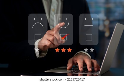 On the virtual screen, a businessman presses the face smiling emoji. Concept for evaluating customer service. User experience or customer satisfaction research can be conducted via a survey, poll. - Powered by Shutterstock