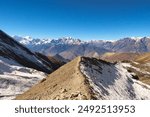 On the way from the Thorong La, Thorung La, Thorang La pass to Muktinath, the trail is running over a small ridge in front of a mountain range, Annapurna Circuit Trek, Nepal 2022