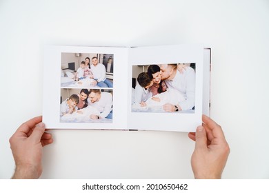 on a white background, hands flip through a photobook from a home family photo shoot with a newborn child. traditions to make a photo album and print photos from important moments of life.