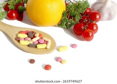 On a white background lies a wooden spoon with medicine and in the background are vegetables and fruits.