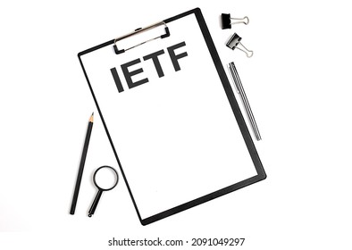 On A White Background Magnifier, A Pen And A Sheet Of Paper With The Text IETF - Internet Engineering Task Force . Business