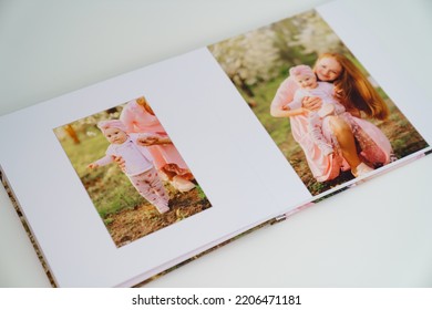 On White Background Open A Photobook From A Family Photo Shoot In The Spring Garden. Tradition Print Photo Album And Review And Remember Moments Of Life. Services Of Photographer And Designer.