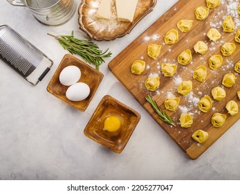 On A White Background, Raw Broken Dumplings On A Wooden Cutting Board, Ingredients And Kitchen Utensils. Lots Of Objects. There Are No People In The Photo. High Angle View.