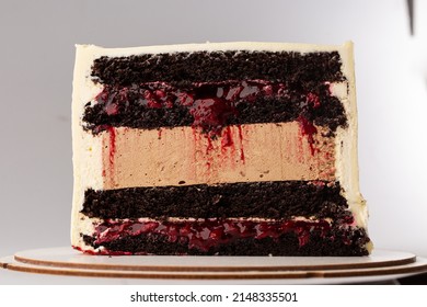 On a white background, a sweet pastry cake is cut in half, the cake is cut in half, the filling and biscuits are visible.Catalog demonstration of products. Minimalistic style. Copy space