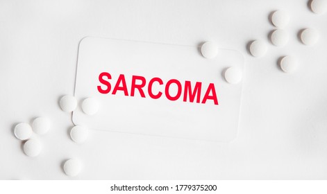 On The White Business Card The Inscription Of Sarcoma, Next To The Tablets.