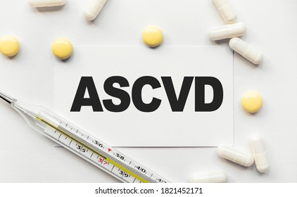 On White Business Card The Inscription ASCVD Atherosclerotic Cardiovascular Disease. Near Tablets And Capsules. Thermometer With High Temperature. Medical Concept. Disease, Treatment And Prevention