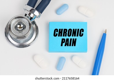 On A White Surface Lie Pills, A Stethoscope And Stickers With The Inscription - CHRONIC PAIN