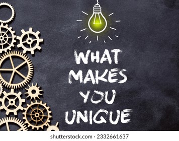 On a white surface, a yellow scroll of paper with the inscription - WHAT MAKES YOU UNIQUE. Business concept