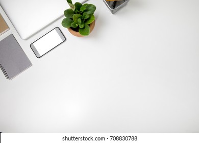 on white table conner left have plant in pot smart phone for review product isolated and notebook grey brown workspace office desk table layout top