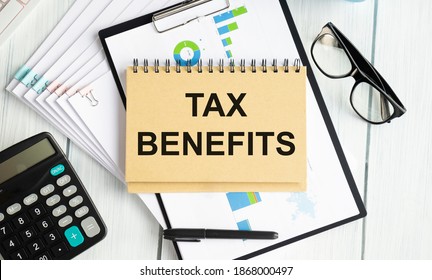 On a white tablet the inscription TAX BENEFITS on the background of accounting.