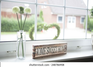 on a window sill in the house is a sign with the text home sweet home