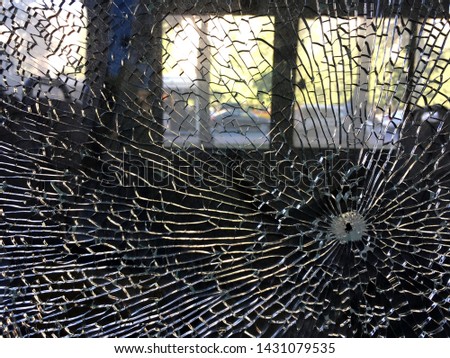 on the windshield of my car trail from a bullet or a stone, which threw the many cracks propagating from the hearth, in the form of web, vandalism