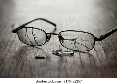 On A Wooden Cracked Background, Men's Glasses With Cracked Glasses And Fragments. Studio Photography