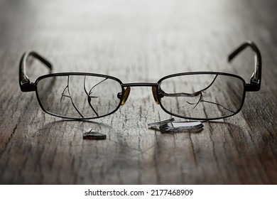 On A Wooden Cracked Background, Men's Glasses With Cracked Glasses And Fragments. Studio Photography