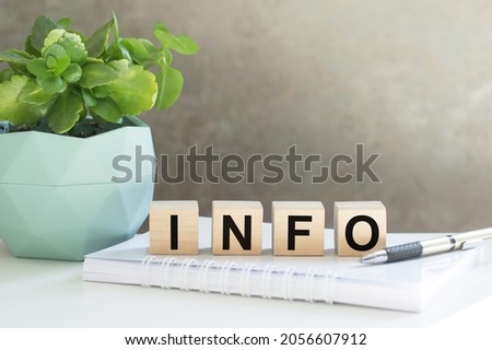 on wooden cubes near a plant in a pot INFO is written