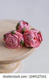 On a wooden round background lie natural marshmallows in the form of pinkroses flowers. Sweet desserts without sugar. Creative baking confectioners. Copy space, mock up. Sweet food