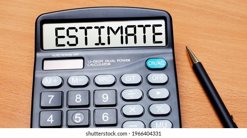 On A Wooden Table There Is A Black Pen And A Calculator With The Text ESTIMATE. Business Concept