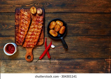 On A Wooden Table Trendy Steakhouse, The Chef Served Pork Ribs Roasted In The Oven And Served With Whole Potatoes