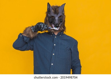 On A Yellow Background Is A Werewolf Dressed In A Blue Shirt Brushing His Teeth With A Blue And White Toothbrush.