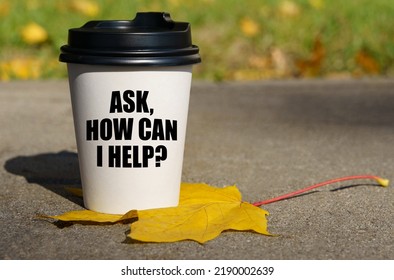 On A Yellow Maple Leaf There Is A Cup Of Coffee On Which Is Written - Ask, How Can I Help. Business Concept.