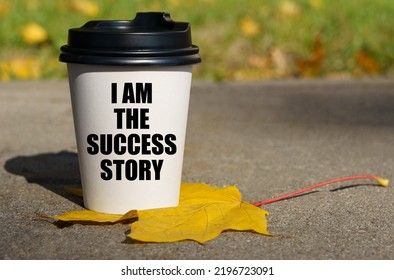 On A Yellow Maple Leaf There Is A Cup Of Coffee On Which Is Written - I Am The Success Story. Business Concept.