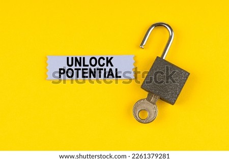 On the yellow surface lies an open lock with a key, next to it is a sticker with the inscription - unlock potential.