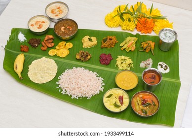 Onam sadhya, Indian women eating with hand boiled rice, served for Kerala Indian festival with curries Sambar, Avial, Thoran, Papadum, Payasam, Banana, Yogurt or Buttermilk, banana chips