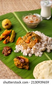 Onam sadhya, Indian women eating with hand boiled rice, served for Kerala Indian festival with curries Sambar, Avial, Thoran, Papadum, Payasam, Banana, Yogurt or Buttermilk, banana chips