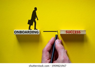 Onboarding success symbol. Wooden blocks with words 'onboarding success'. Businessman hand. Beautiful yellow background, copy space. Business and onboarding success concept.