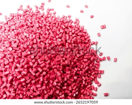 Oncolor red masterbatch plastic granules, polymer carries colorful pigments poured into a white background, suitable for product catalog design of industrial plastic manufacturing company profiles