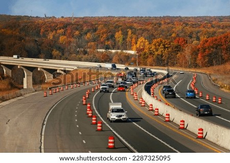 Oncoming traffic on the Ohio Turnpike rounds a curve after crossing the Cuyahoga Valley in autumn.