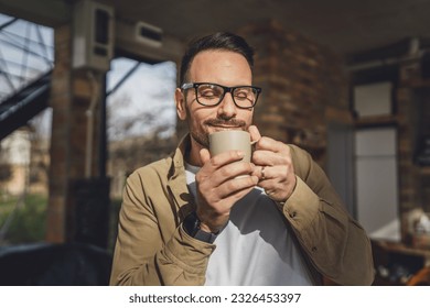 One adult caucasian man stand outdoor in front of his house in sunny morning or day enjoy cup of tea or coffee real people daily routine happy smile copy space - Powered by Shutterstock