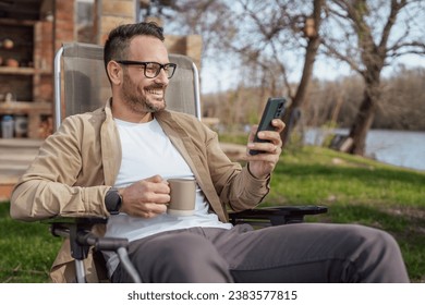 One adult man 40 years old caucasian male sit in front of his house on vacation talk on his smartphone mobile phone call happy smile during the conversation real person copy space - Powered by Shutterstock