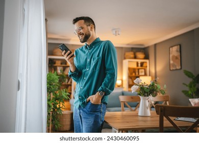 One adult man with eyeglasses stand at home use mobile phone talk - Powered by Shutterstock