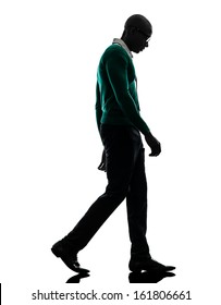 One African  Black Man Walking Looking Down Sad  In Silhouette Studio On White Background