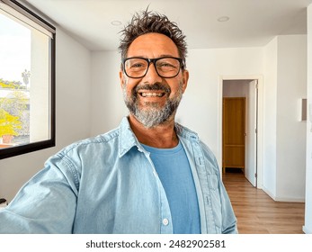 One alone man taking selfie picture in new home empty apartment. New life beginning concept people. Real estate buyer smile inside propery loan mortgage. Phone camera portrait mature happy male indoor