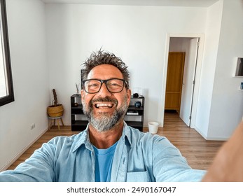 One alone man taking selfie picture in new home empty apartment. New life beginning concept people. Real estate buyer smile inside propery loan mortgage. Phone camera portrait mature happy male indoor